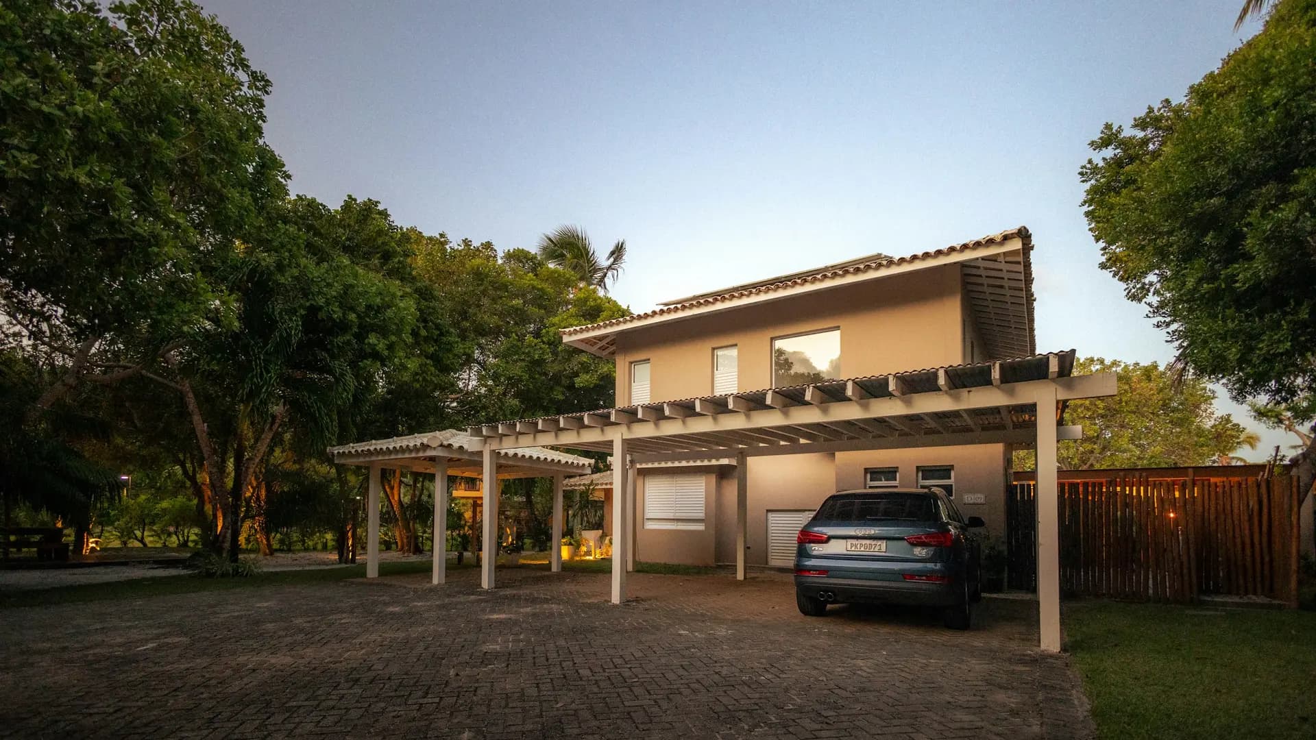 Family home with pergola carport at dusk